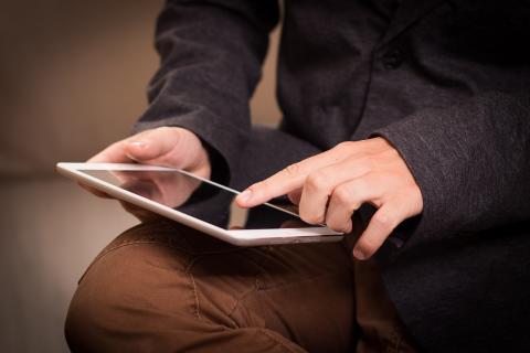 Picture of a person holding and touching an iPad