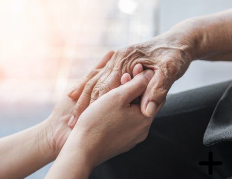 Someone holding the hand of an elderly person