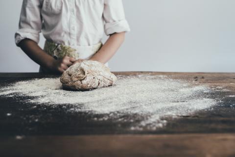 Picture of chef with a loaf of bread dough on a counter